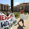 Protesters march past the Arizona State Capital Building as they campaign against the controversial state law SB1070