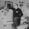 Enrico Caruso standing by his piano